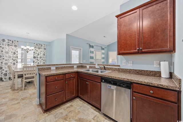 kitchen featuring dark countertops, a peninsula, stainless steel dishwasher, pendant lighting, and a sink