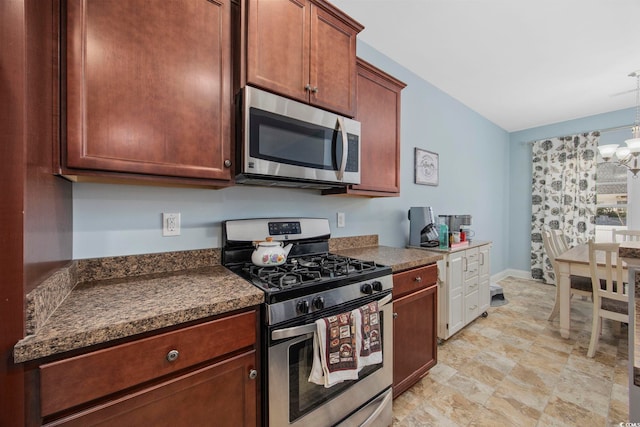 kitchen with dark countertops, baseboards, a chandelier, and stainless steel appliances