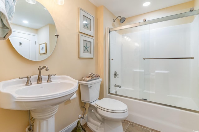 bathroom featuring combined bath / shower with glass door, tile patterned flooring, and toilet