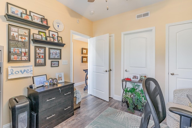 office area with a ceiling fan, baseboards, visible vents, and dark wood-type flooring