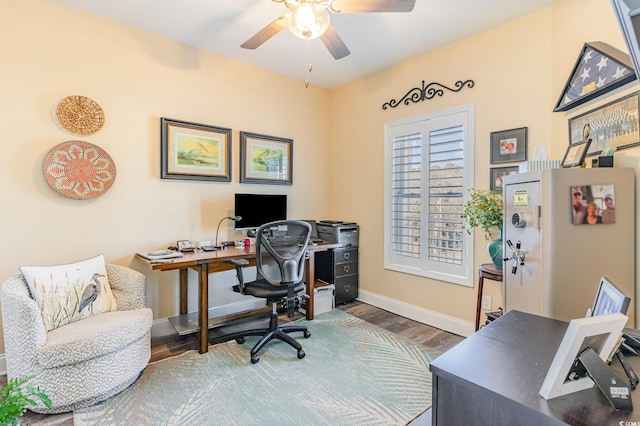 home office with a ceiling fan, baseboards, and wood finished floors