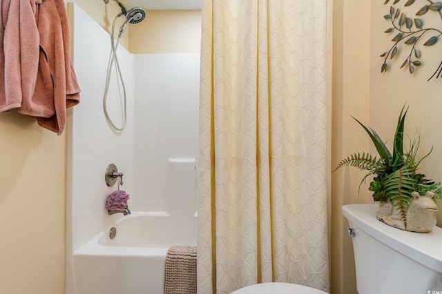 bathroom with shower / bathtub combination with curtain and toilet