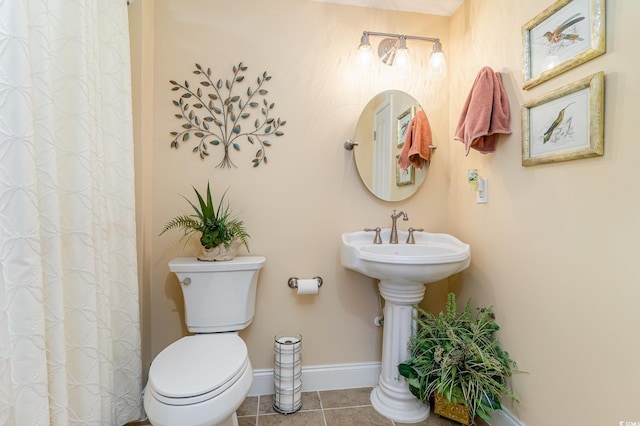 bathroom with baseboards, a shower with shower curtain, toilet, and tile patterned floors