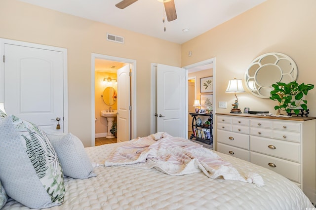 bedroom with ceiling fan, connected bathroom, visible vents, and tile patterned floors