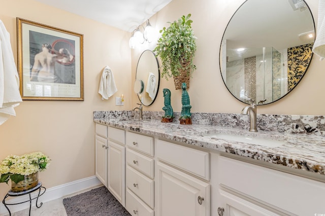 bathroom featuring double vanity, visible vents, an enclosed shower, a sink, and baseboards