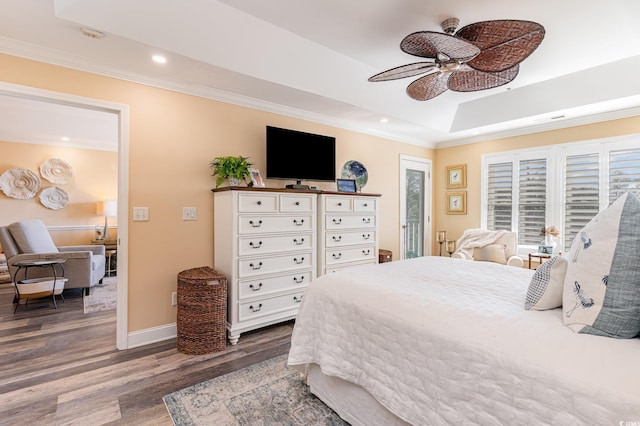 bedroom with recessed lighting, wood finished floors, baseboards, ornamental molding, and a raised ceiling