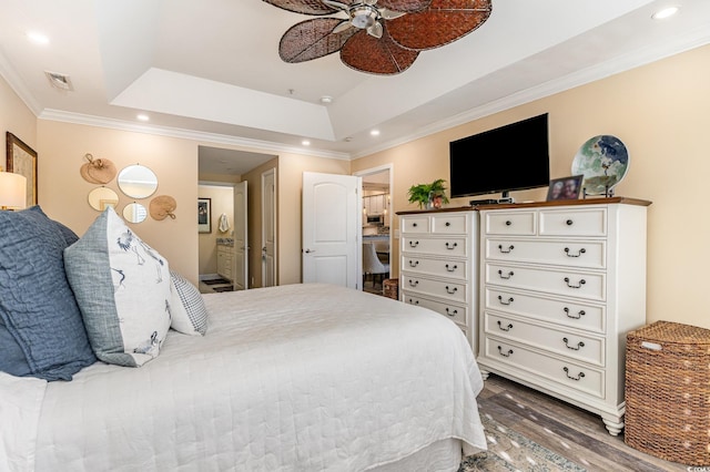 bedroom featuring a tray ceiling, wood finished floors, visible vents, and recessed lighting