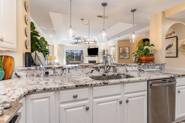 kitchen featuring ornamental molding, a sink, a tray ceiling, white cabinetry, and stainless steel dishwasher