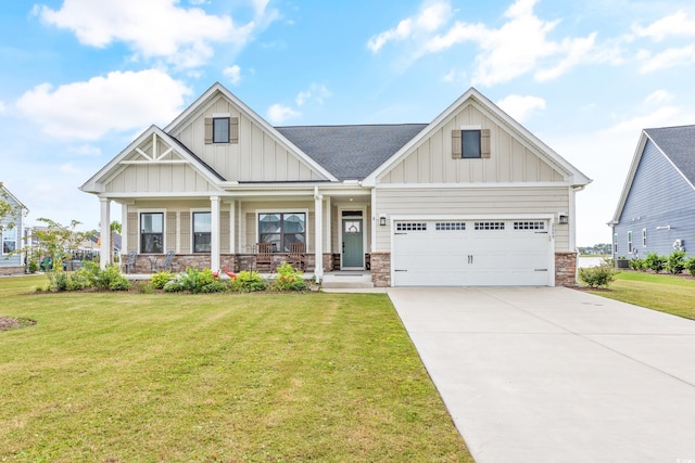 craftsman inspired home with covered porch, driveway, a front lawn, and board and batten siding