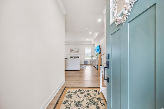 entrance foyer featuring recessed lighting, a fireplace, baseboards, light wood-type flooring, and crown molding