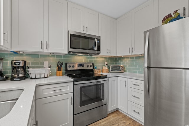 207 3rd Ave N Unit 348, North Myrtle Beach, SC 29582 - kitchen featuring appliances with stainless steel finishes, light countertops, white cabinets, and tasteful backsplash