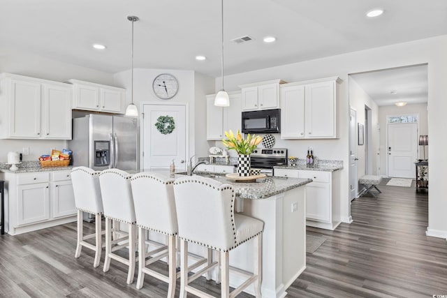 kitchen featuring a kitchen bar, dark wood-style flooring, stainless steel appliances, and a sink