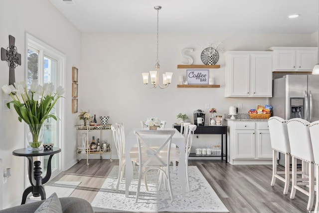 kitchen featuring light stone countertops, white cabinets, light wood-style flooring, and an inviting chandelier