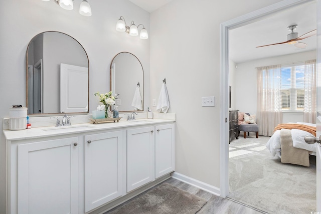 ensuite bathroom featuring a sink, double vanity, a ceiling fan, and connected bathroom