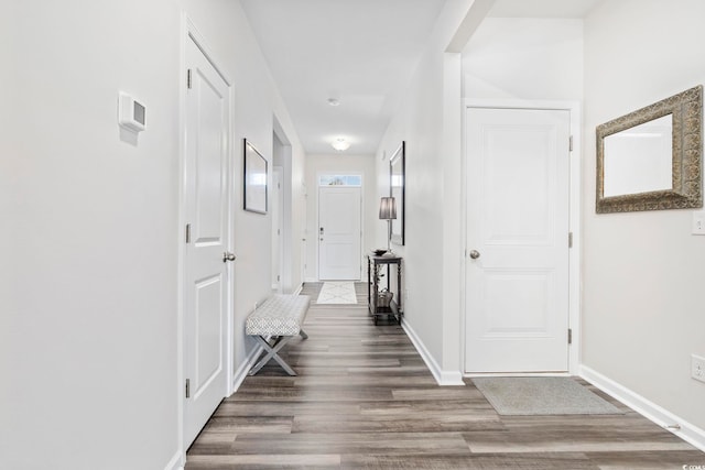 hallway featuring baseboards and wood finished floors