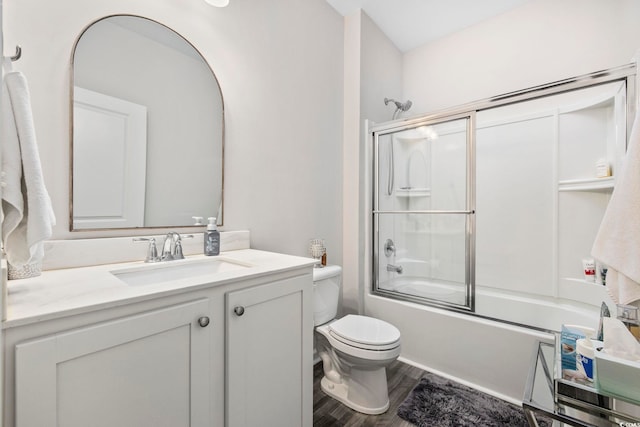 full bathroom with vanity, combined bath / shower with glass door, wood finished floors, and toilet