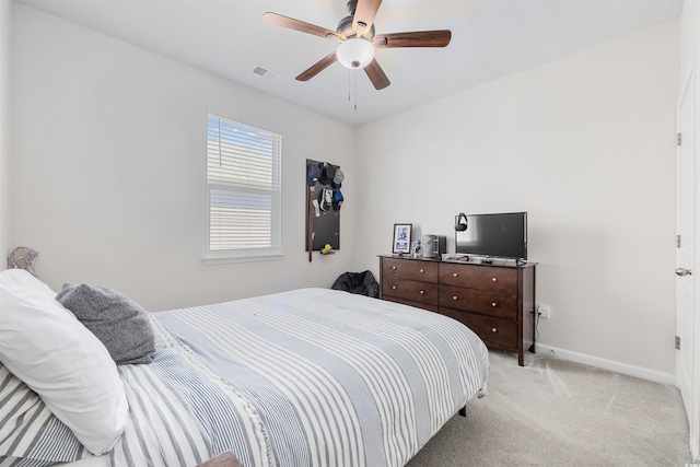 bedroom with a ceiling fan, light colored carpet, visible vents, and baseboards