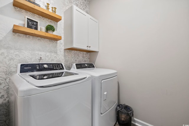 washroom with cabinet space, baseboards, and separate washer and dryer