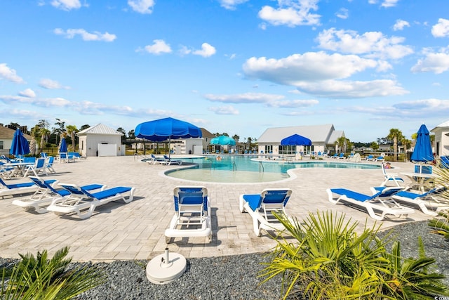 community pool with a patio area and fence