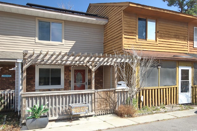 view of front of property with covered porch and a pergola