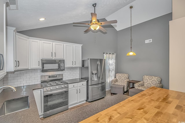 kitchen featuring lofted ceiling, ceiling fan, appliances with stainless steel finishes, and a sink