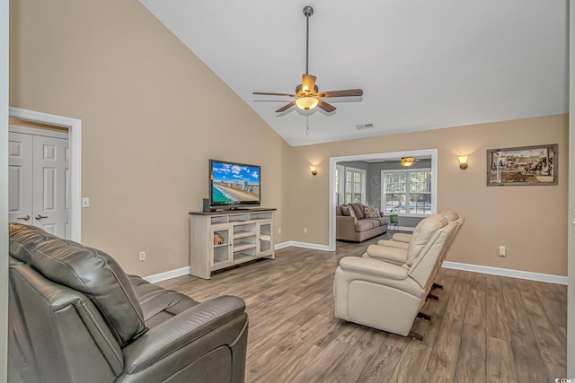 living room featuring visible vents, a ceiling fan, wood finished floors, high vaulted ceiling, and baseboards