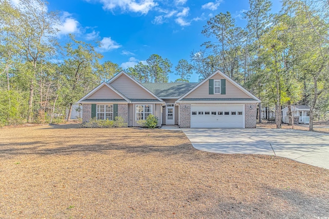 view of front of property with a garage, concrete driveway, brick siding, and a front lawn