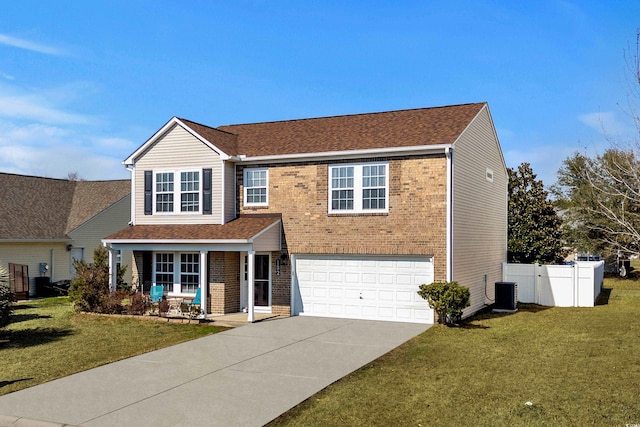 traditional home featuring brick siding, a front lawn, fence, a garage, and driveway