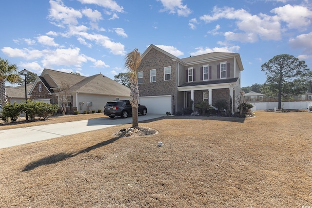 traditional-style home featuring an attached garage, a front yard, concrete driveway, and brick siding