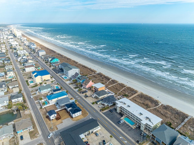 drone / aerial view with a water view and a beach view