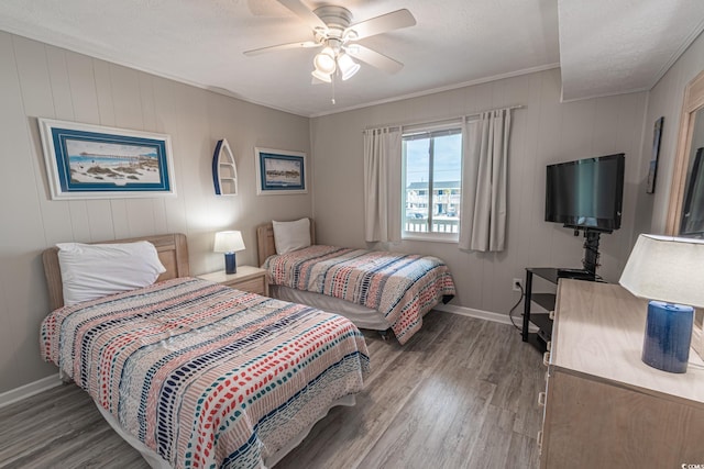 bedroom with ceiling fan, ornamental molding, wood finished floors, and baseboards