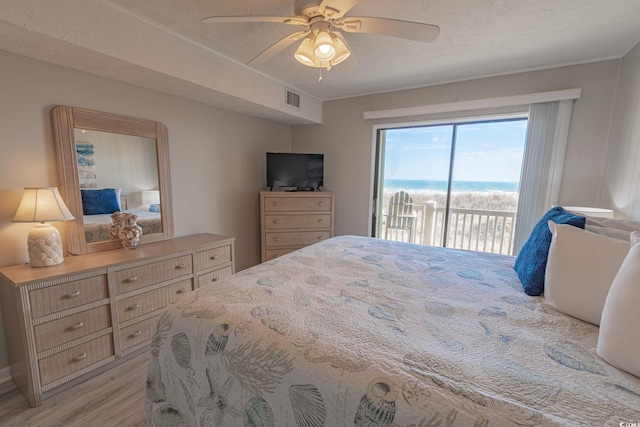 bedroom featuring access to exterior, visible vents, light wood-style floors, and a ceiling fan