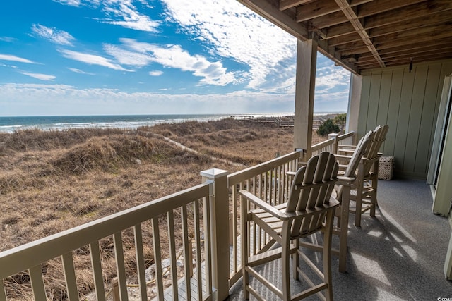 balcony featuring a water view and a beach view