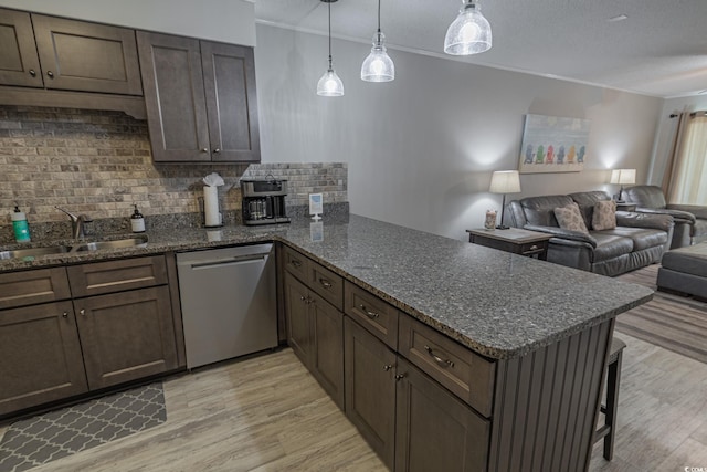 kitchen with light wood-style flooring, a peninsula, a sink, open floor plan, and dishwasher