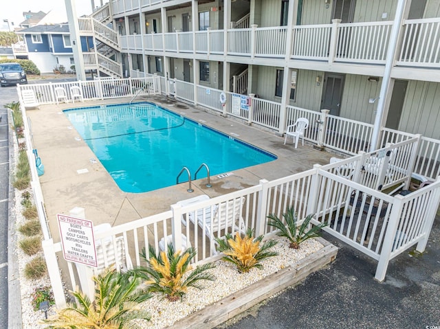 community pool featuring a patio area and fence