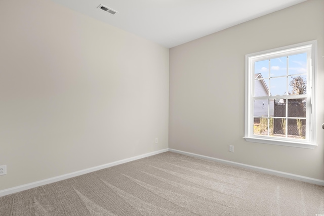 carpeted spare room featuring visible vents and baseboards