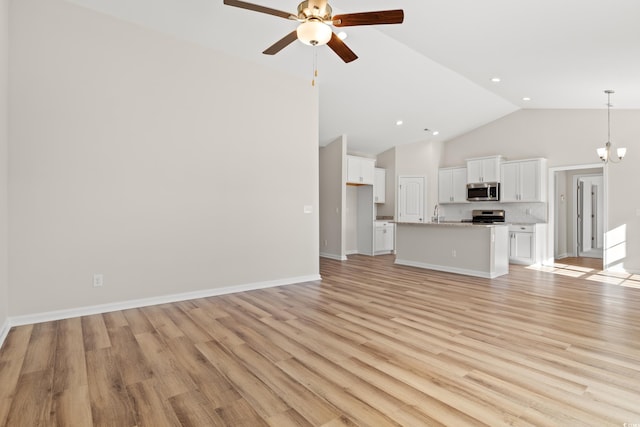 unfurnished living room with high vaulted ceiling, baseboards, light wood finished floors, and ceiling fan with notable chandelier