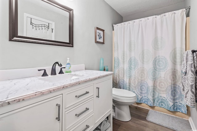 full bathroom with a textured ceiling, vanity, wood finished floors, and toilet