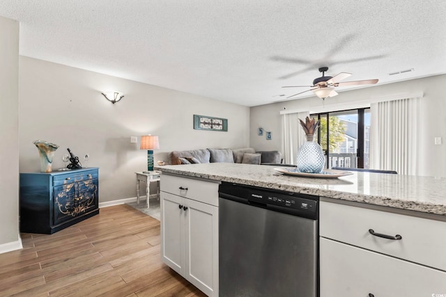 kitchen with visible vents, white cabinets, light wood-style flooring, open floor plan, and stainless steel dishwasher