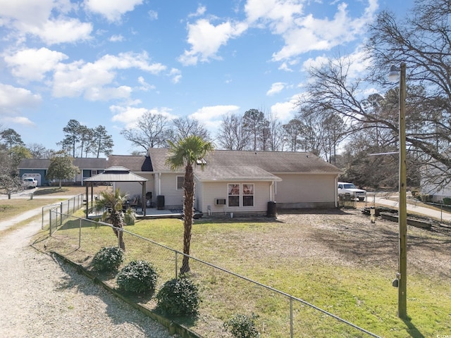 view of front of house with a front yard, dirt driveway, fence, and a gazebo