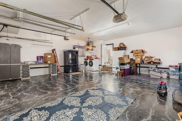 garage with a garage door opener, washer and clothes dryer, and black refrigerator with ice dispenser