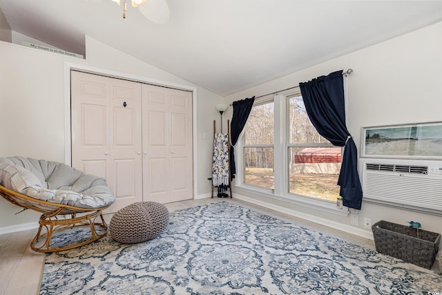 sitting room with vaulted ceiling, baseboards, and wood finished floors