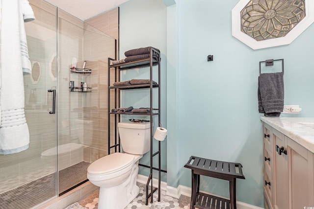 full bathroom with a stall shower, baseboards, vanity, and toilet