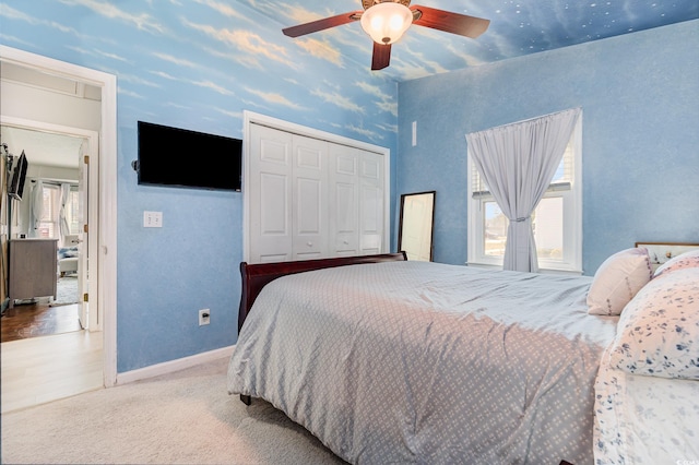 bedroom featuring ceiling fan, carpet floors, a closet, and baseboards