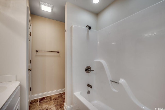bathroom featuring baseboards, washtub / shower combination, visible vents, and vanity