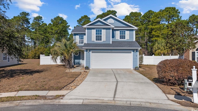 view of front of house featuring driveway, an attached garage, and fence