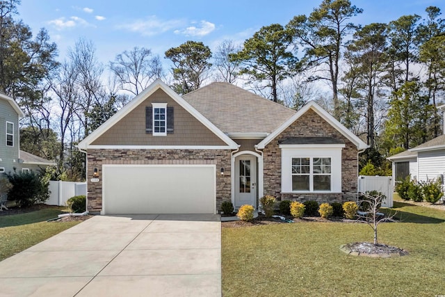 craftsman-style home featuring a front yard, fence, and driveway