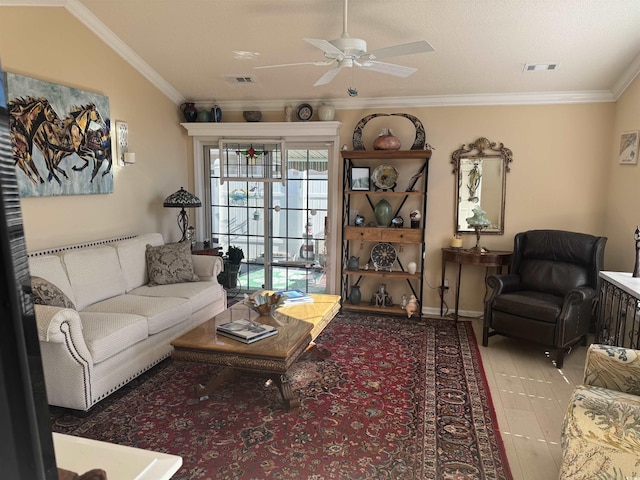 living room with visible vents, baseboards, crown molding, and a ceiling fan