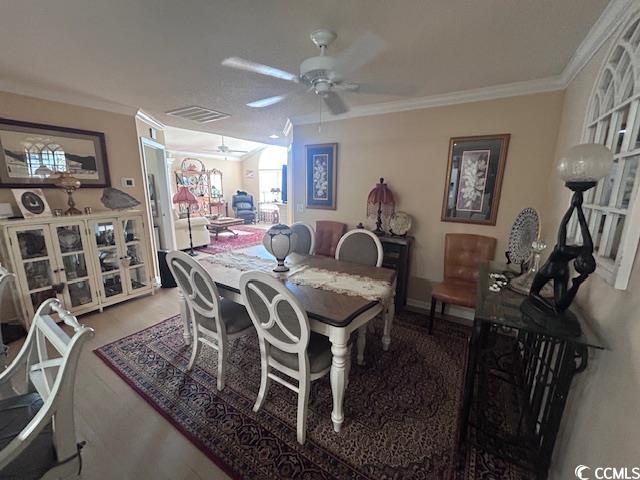 dining room featuring ornamental molding, a ceiling fan, and wood finished floors
