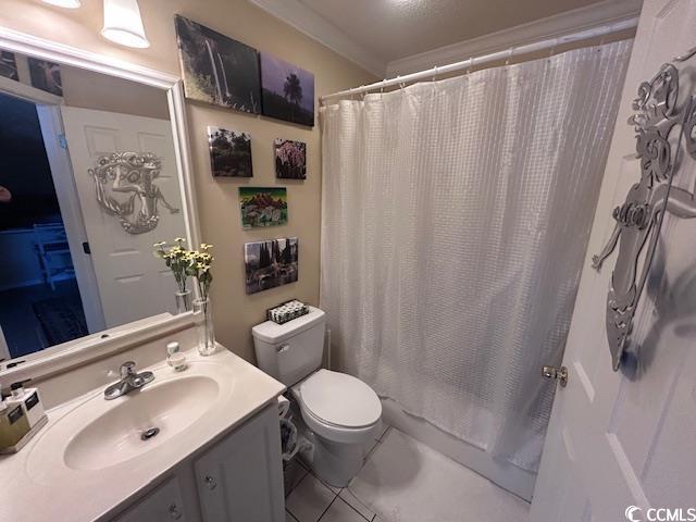 bathroom featuring vanity, tile patterned floors, toilet, and shower / bath combo with shower curtain